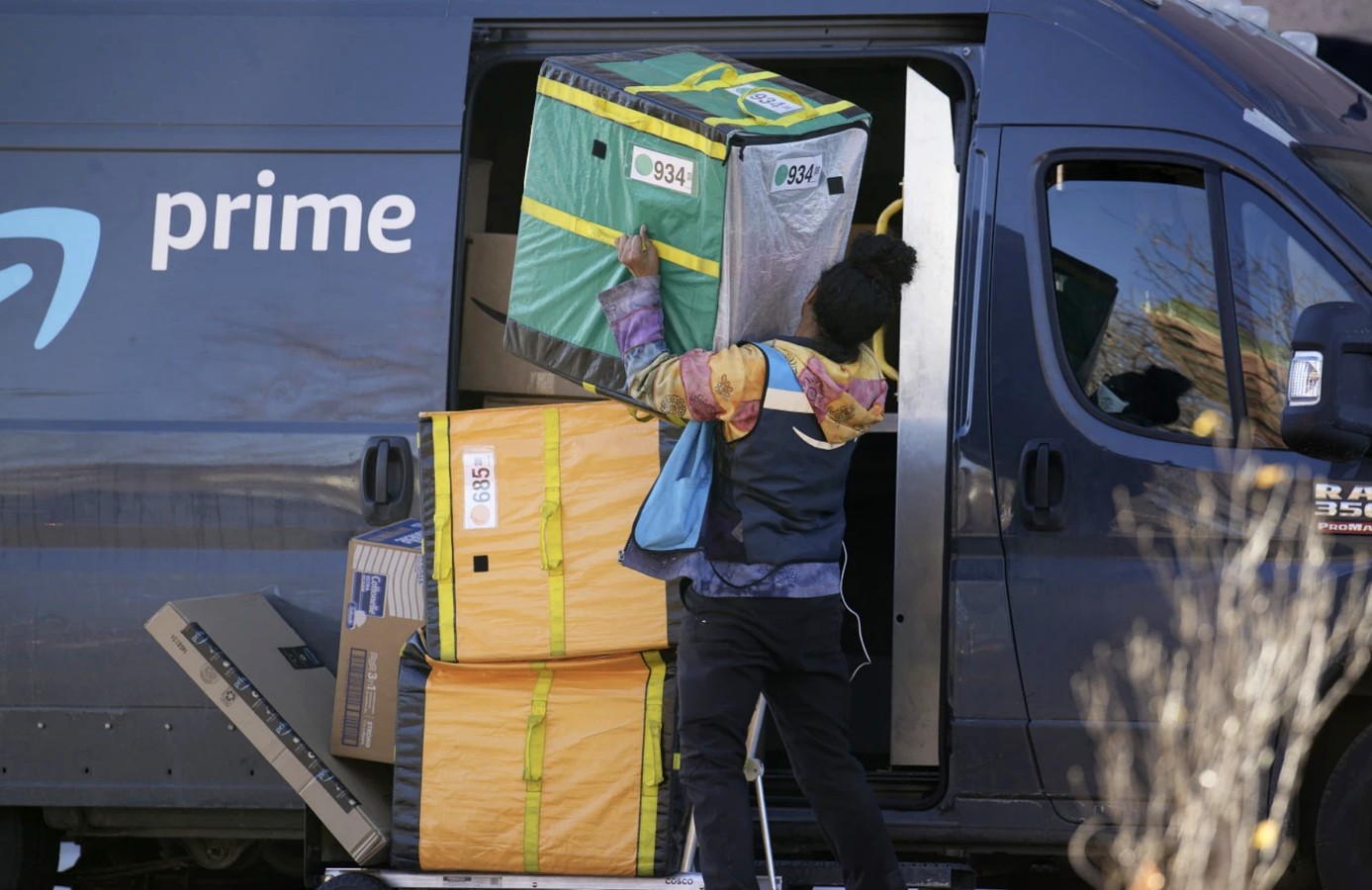 Amazon Prime delivery person lifting packages at a high-rise apartment building